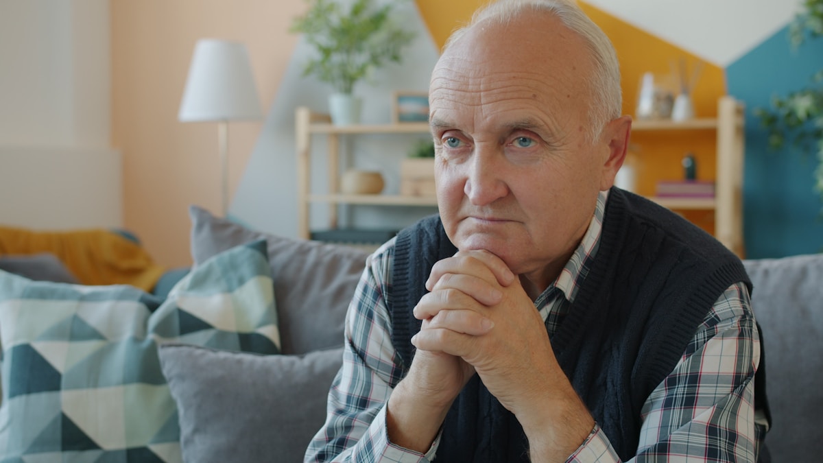 Older man looking worried at phone call — Medicare scam warning